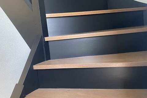 Escalier peint noir et bois.